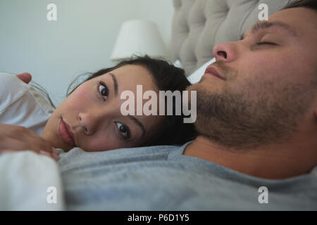 Couple sleeping on bed in bedroom Stock Photo