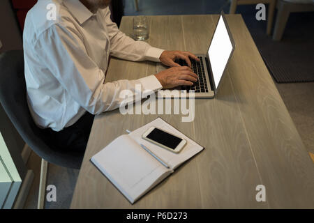 Businessman using a laptop at desk Stock Photo