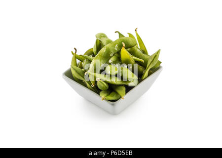 Japanese asian food edamame nibbles, boiled green soy beans with salt isolated on white. Stock Photo
