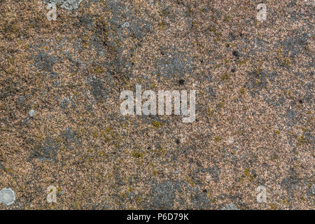 Natural granite stone texture, red with white and gray lichen. Stock Photo
