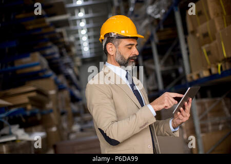 Portrait of middle-aged businessman with digital tablet in factory Stock Photo