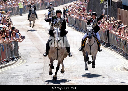 Galashiels, Scotland, UK, June 30:    Braw Lads' Day 2018 (Braw Lads Gathering) Bearer of the Sod 2018: Ex Braw Lad (2017) Greg Robertson and Bearer of the Red Roses 2018 : Ex Braw Lass (2017) Amy Thomson galloping up Scott Street during the Braw Lads Gathering annual festival, part of the Scottish Common Riding season, on June 30, 2018 in Galashiels. Established in 1930 to celebrate the town's history.  Credit: Rob Gray/Alamy Live News Stock Photo