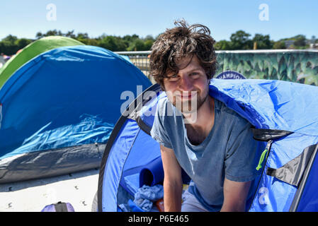 London, UK.  30 June 2018.  Darius Platt-Vowles from Gloucestershire poses in his tent in Wimbledon Park.  He is the first in 'The Queue' for premium tickets, having arrived on Thursday 28 June, four days before the Wimbledon tennis championships are to begin on 2 July.  He hopes to be able to obtain tickets to centre court to see his idol, Roger Federer.  Credit: Stephen Chung / Alamy Live News Stock Photo