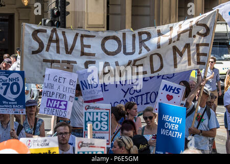 London, UK. 30 June, 2018. A large banner amongst the placards reads ' Save our NHS, It saved me'. With the NHS 70 years old this year, thousands marched through central London in a National rally to show support for the service and to demand more funding from the Government. David Rowe/Alamy Live News Stock Photo