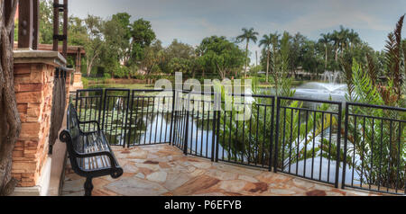 Bench overlooking a pond at the Garden of Hope and Courage memorial garden and sanctuary in Naples, Florida. Stock Photo