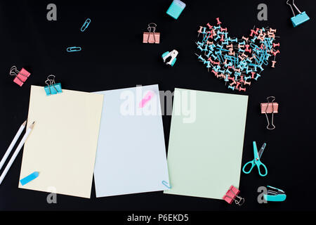 Many multi-colored clips on a black background. Office concept. Subjects for the school. copy space Stock Photo