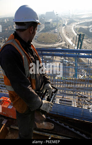 A man operating the controls of a hoist at a working construction building site in Leeds, Yorkshire Stock Photo