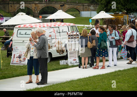 People standing by Bonne Maman van food stall, buying & eating refreshments - RHS Chatsworth Flower Show, Chatsworth House, Derbyshire, England, UK. Stock Photo