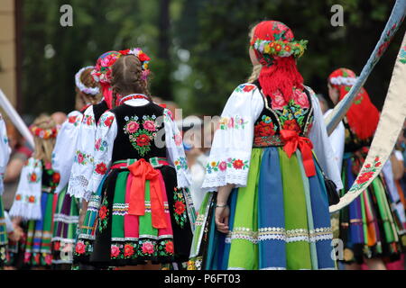 Group of polish women dressed in graditional folk colorful costumes from lowicz region in Poland, local generations, join Corpus Christi procession Stock Photo