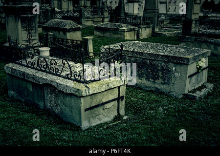 Ancient tombs in a cemetery, detail from a grave in an old abandoned Christian cemetery Stock Photo
