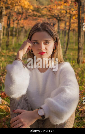 girl sitting in the nature under a gabled vine Stock Photo