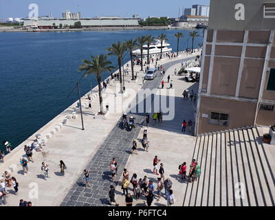Brindisi, Italy - April 30, 2018: Promenade on the port of Brindisi and tourists Stock Photo