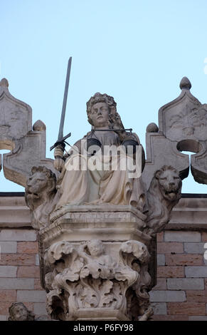 Goddess of Justice, statue at the top of Doge Palace in Venice, holding balance scales and sword, erected in 1579, Venice, Italy Stock Photo