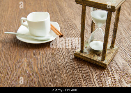 Hourglass on the Oak table as time passing concept for business deadline, urgency and running out of time. Stock Photo