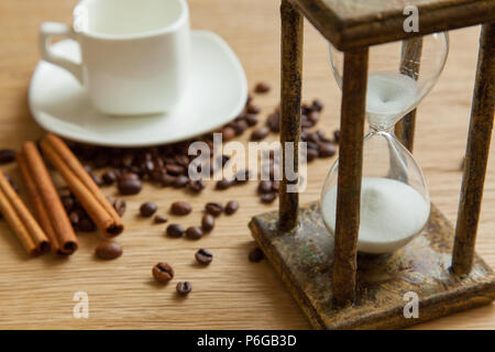 Hourglass on the Oak table as time passing concept for business deadline, urgency and running out of time. Stock Photo