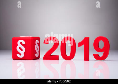 Red Cube With Paragraph Symbol Besides Year 2019 On Reflective Background Stock Photo