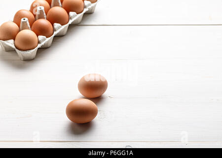 red chicken eggs in different shades on a white wooden background Stock Photo