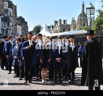 Cambridge UK, June 27 2018: Cambridge University students from Trinity college in blue gowns waiting on Kings parade outside the Senate House for thei Stock Photo