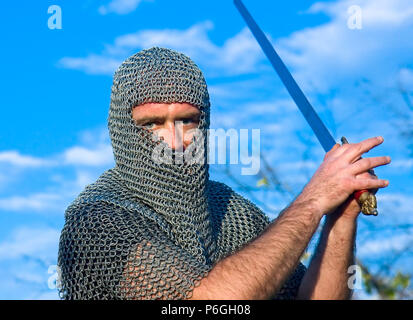 Knight warrior wearing armour and hold on a sword Stock Photo