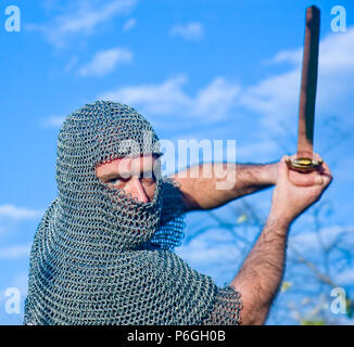 Knight warrior wearing armour and hold on a sword Stock Photo