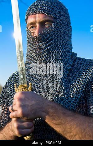 Knight warrior wearing armour and hold on a sword Stock Photo