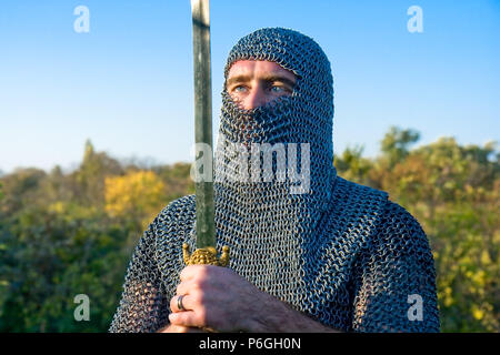 Knight warrior wearing armour and hold on a sword Stock Photo