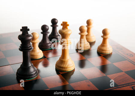 chess duel of two kings and pawns on a chessboard on a white background close up Stock Photo