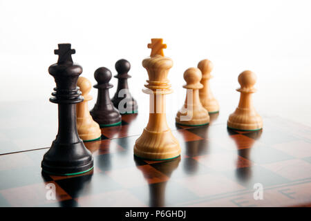 chess duel of two kings and pawns on a white background close up Stock Photo