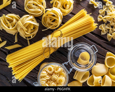 Different pasta types on the wooden table. Stock Photo