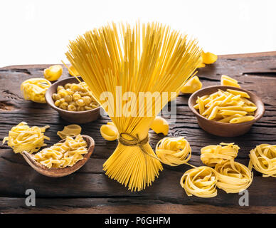 Different pasta types on wooden table. White background. Stock Photo