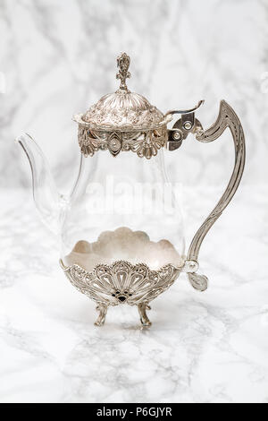 Decorative glass and metal jug on white marble Stock Photo
