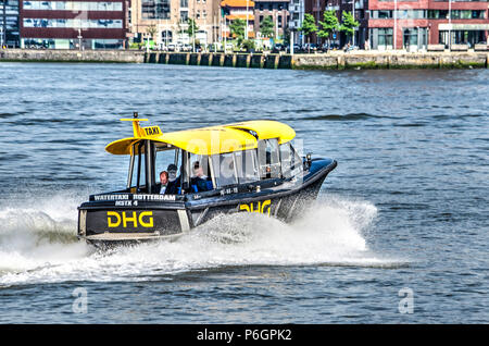 Rotterdam, The Netherlands, May 31, 2018: a characteristic yellow watertaxi is rushing by on the river Nieuwe Maas