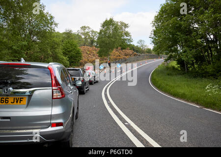 cars waiting at temporary lights at roadworks on a no overtaking section of the a591  near keswick in the lake district cumbria england uk Stock Photo