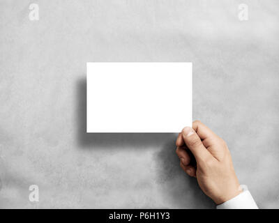Hand holding blank white postcard flyer mockup. 6 x 4 leaflet mock up presentation. Postal holder. Man show clear post card paper. Sheet template. Invitation booklet reading first person view Stock Photo