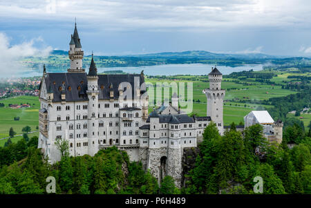 Castel called Neuschwanstein in bavaria with clouds on the sky and a little fog on a sunny day Stock Photo