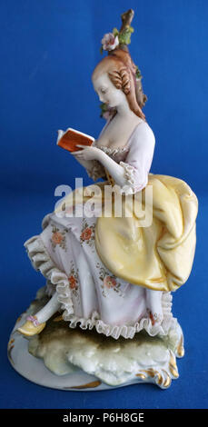 Vintage Capodimonte Italian Porcelain Figure or Figurine Girl wearing lace trimmed dress reading a book Stock Photo