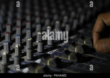 close up view of knobs and sliders of light and sound board console at a concert theater Stock Photo