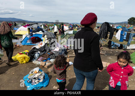 A refugee on a muddy field after a raining night at the makeshift refugee camp of the Greek-Macedonian border near the Greek village of Idomeni. Stock Photo