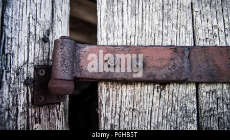 Rusted hinge on a wooden door Stock Photo