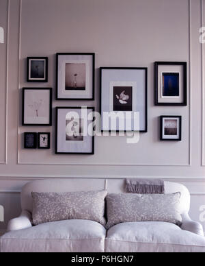 Framed black+white photographs on either side of mirror above low