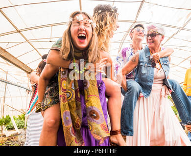 girls going crazy in party celebrating with hippies clothes and freedom algernative rebel concept. happiness with girls carrying on backpacks and havi Stock Photo