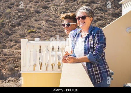 nice afternoon for couple of caucasian grandmother and teenager nephew staying together enjoying the sun on the terrace at home. leisure activity in f Stock Photo