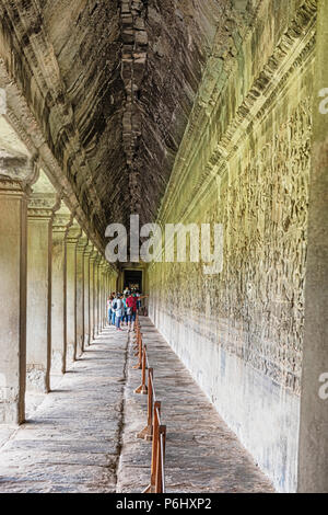 Angkor Wat, Cambodia - November 17, 2017: Tourists visiting gallery in Angkor Wat temple. It is the largest religious complex in the world and was bui Stock Photo