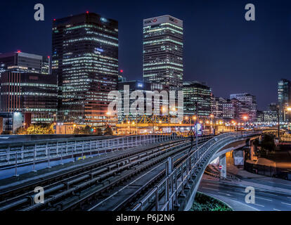 30 September 2015 - London, England. Futuristic night cityscape view of DLR railroad leading into the financial district towers of Canary Wharf, Londo Stock Photo