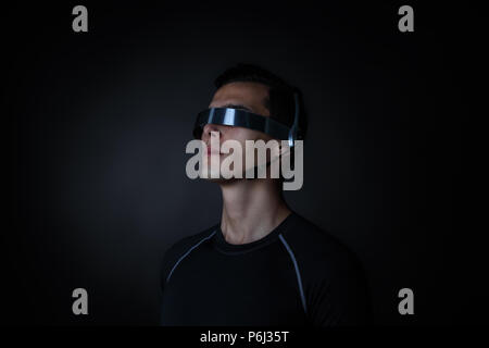 Man using futuristic VR goggles headset with microphone Stock Photo