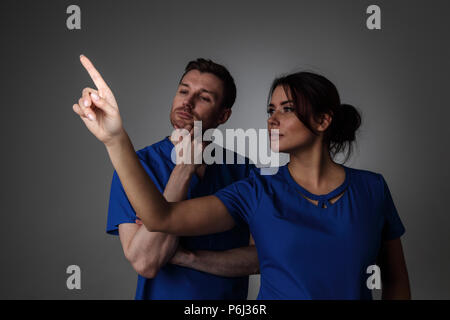Healthcare, medicine and technology concept - two doctors pointing to something or pressing imaginary button Stock Photo