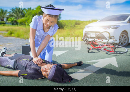 Female nurse helping emergency CPR to asia cyclist injured on the ...