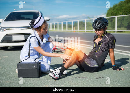 Female nurse helping emergency asia cyclist injured on the street bike ...