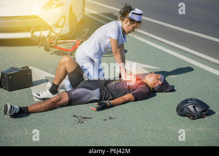 Female nurse helping emergency CPR to asia cyclist injured on the street bike after collision accident car and bike Stock Photo