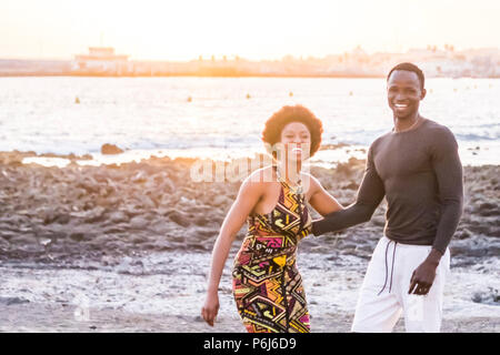 Happy black african race skin couple together having fun at the beach in vacation. happiness concept with two young man and woman having fun together. Stock Photo
